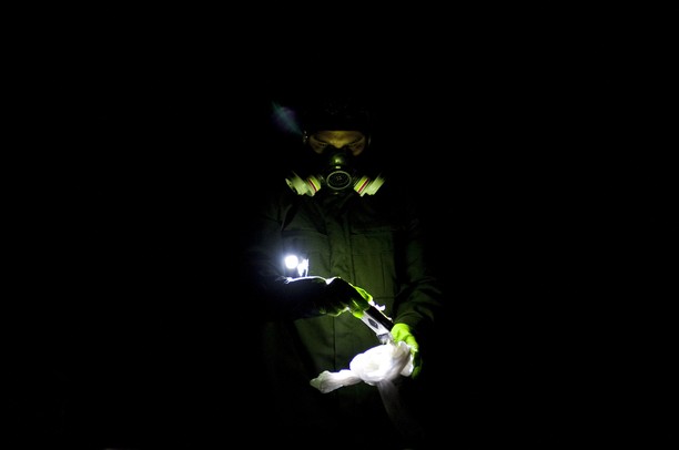 A member of the Michigan State Police Meth Response Team collects evidence and neutralizes hazardous material removed from a Ford Mustang on Briarbrook Drive in Ypsilanti on Monday. They were alerted after a man was found making meth in the front seat of the car. Daniel Brenner I AnnArbor.com